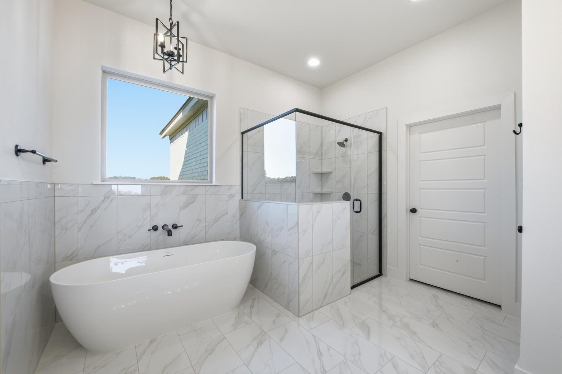 Primary bath with freestanding tub and glass shower in a Poolville Abba River Homes build.